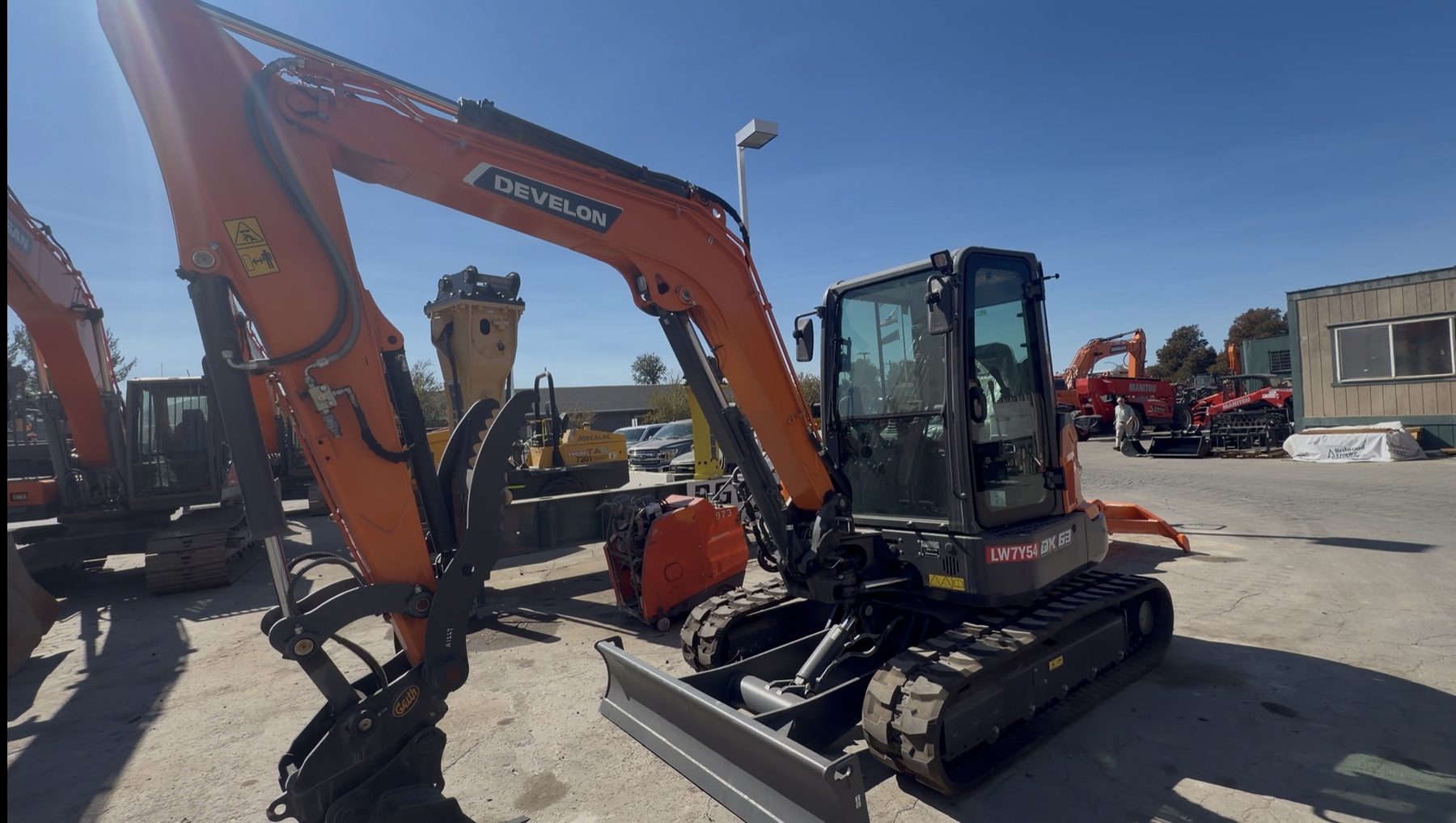 Develon DX63-7 enclosed cab excavator with backfill blade